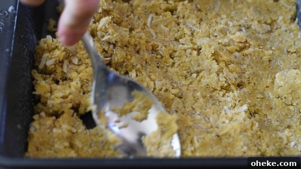 Paleo Lemon Bars with Almond-Coconut Crust Recipe 5 Using a large spoon to press the crust to a pan.