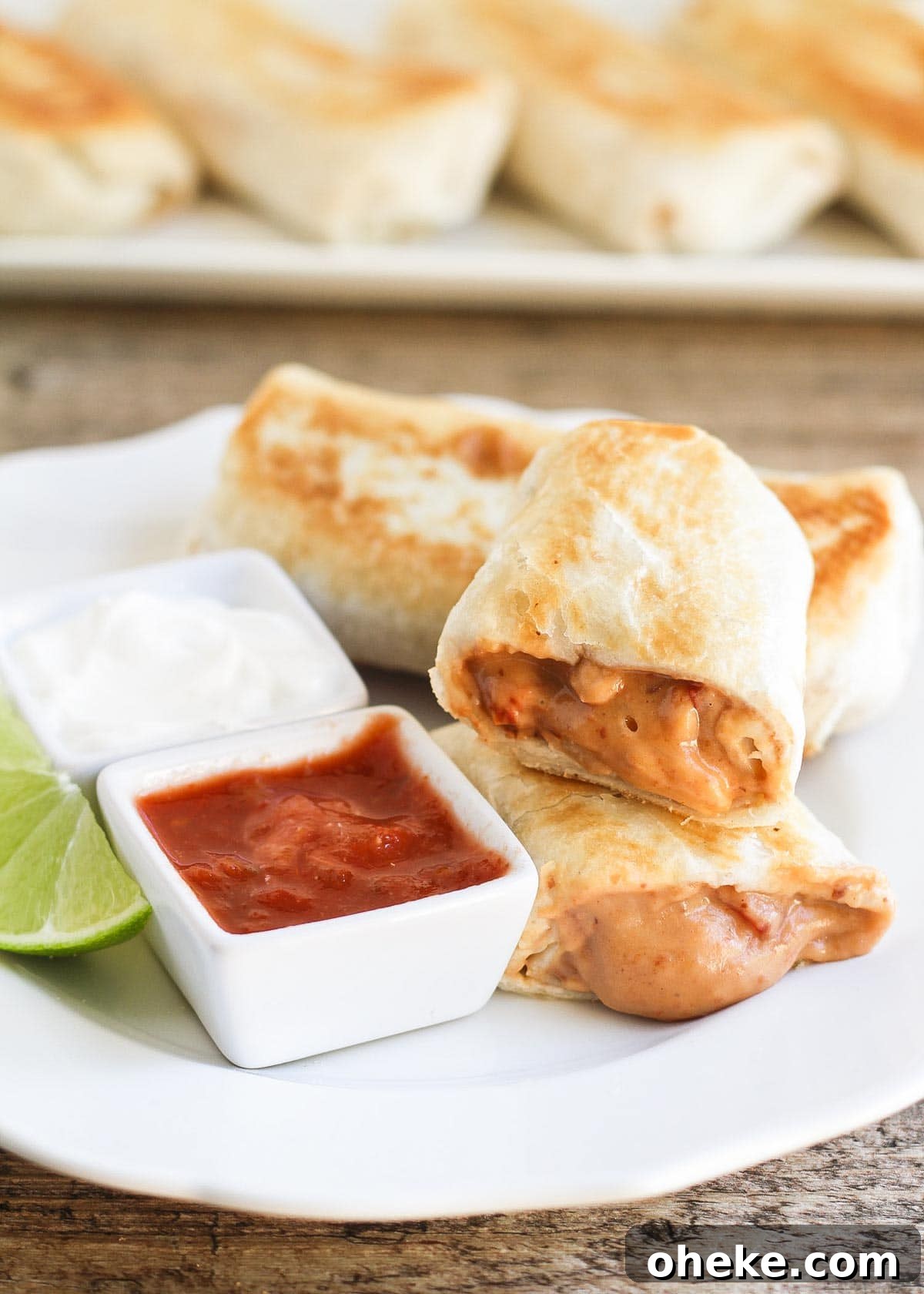 Easy and delicious Bean Chimichangas are filled with beans, cheese and ROTEL and they taste just like the ones at the restaurants! Bean and cheese chimichanga on a plate with salsa and sour cream