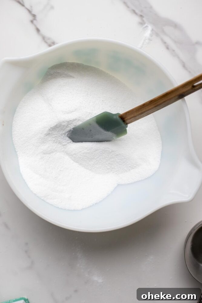 Ingredients in a bowl with a silicon spatula mixing the ingredients together.