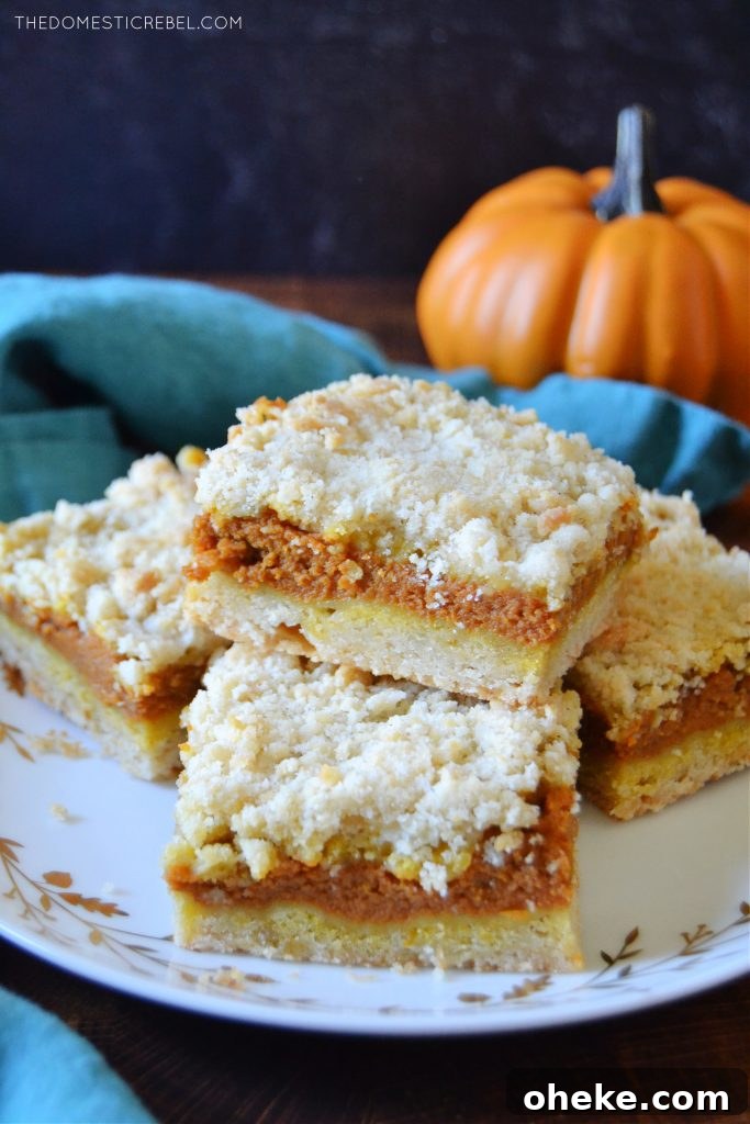 Pumpkin Pie Crumble Bars Recipe — Fall Dessert Bars 6 a plateful of pumpkin pie crumble bars with a pumpkin in the background