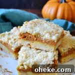 Pumpkin Pie Crumble Bars Recipe — Fall Dessert Bars 7 a plate of pumpkin pie crumble bars on a teal towel