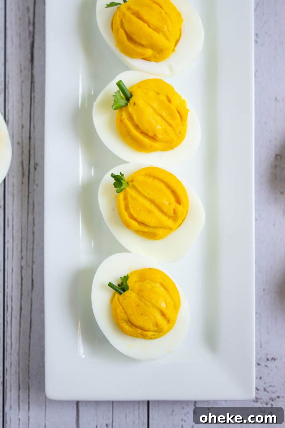 Pumpkin-Spiced Deviled Eggs for Low-Carb Fall Brunch 3 overhead view of pumpkin deviled eggs on a long platter