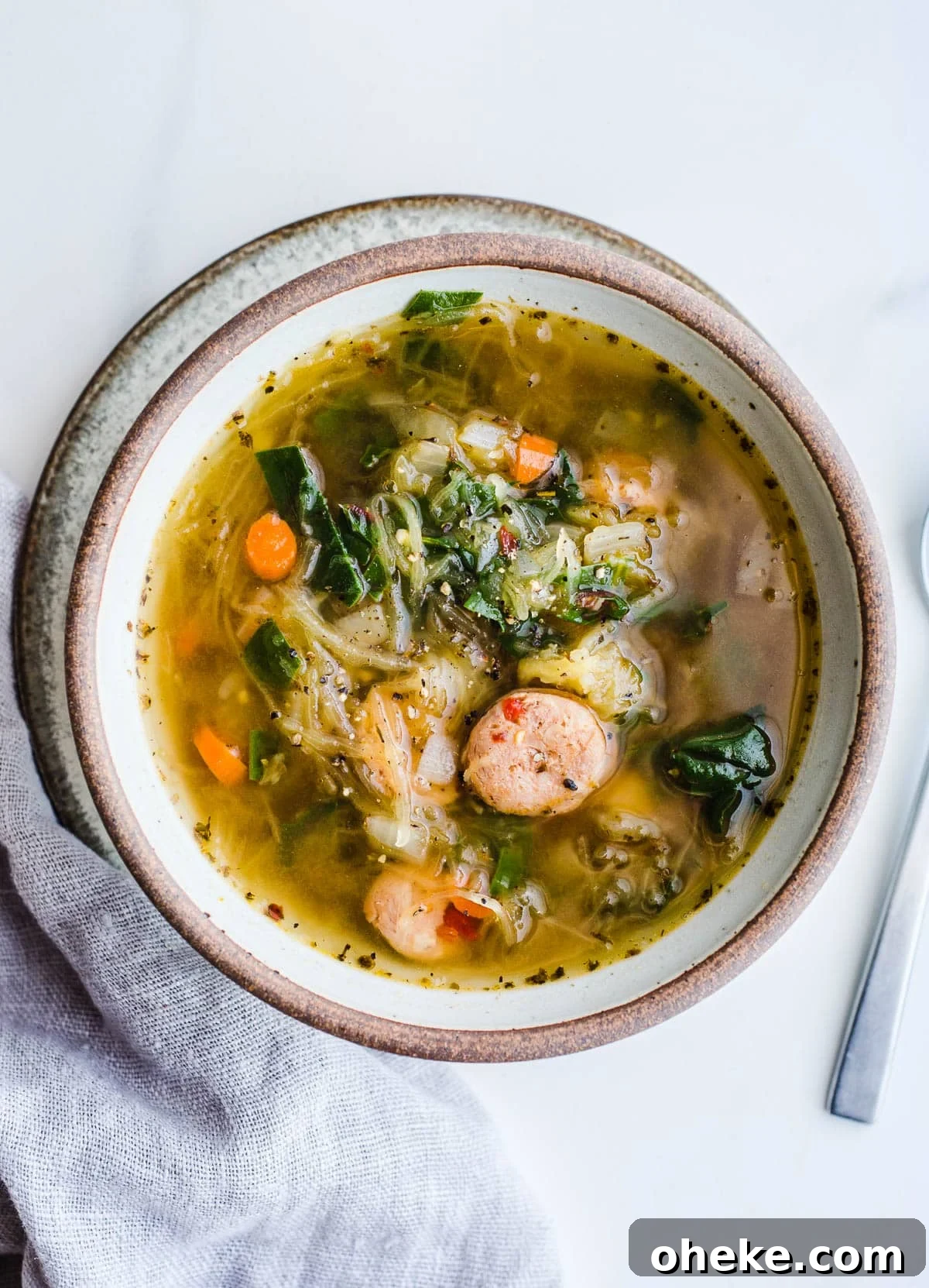 Vegetable and sausage soup in a rustic bowl.
