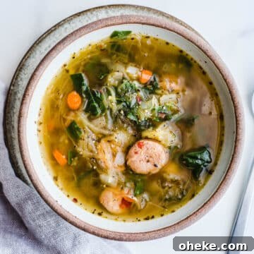 Squash and sausage soup in a rustic bowl.