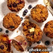 Moist Buttermilk Blueberry Muffins Recipe for Perfect Muffins 13 Buttermilk blueberry muffins spread out on a white background with one muffin sliced open.