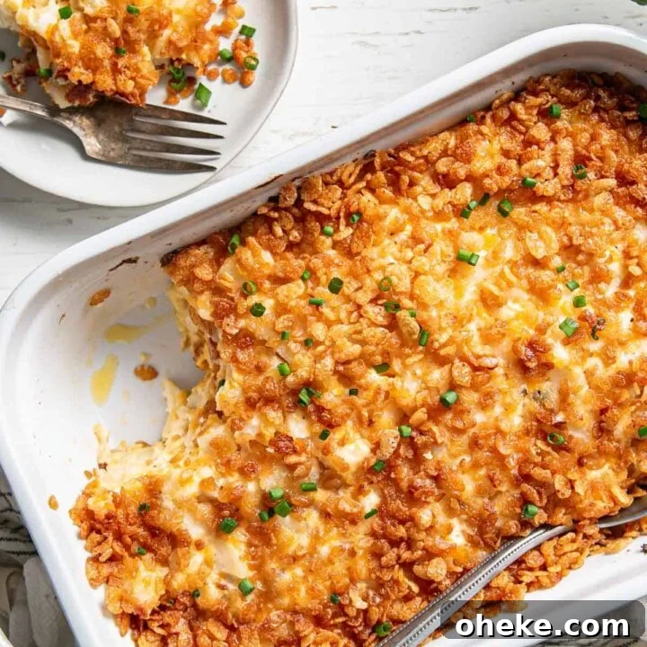 Gluten-free Hashbrown Casserole in a white dish, scoop removed on a plate.