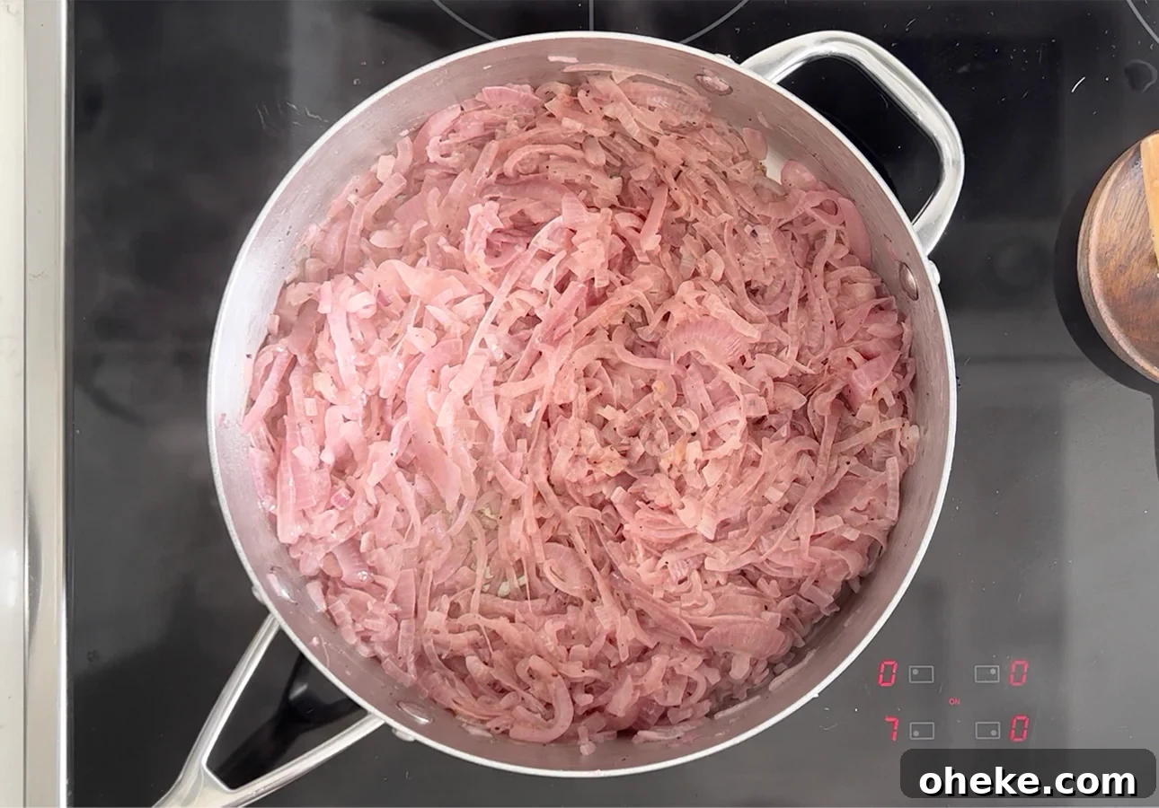 Pissaladière: French Onion and Anchovy Tart Recipe (Video) 5 A pot of thinly sliced onions cooking to translucent softness