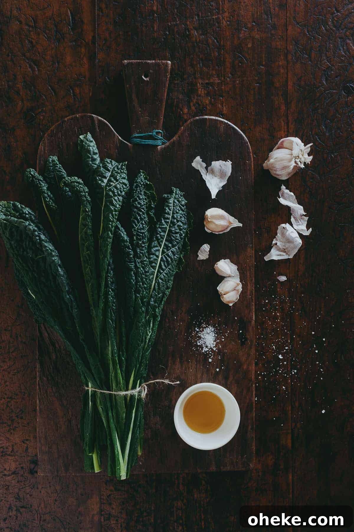 Tuscan Black Kale: Nutritional Benefits and Cooking Ideas 4 a bunch of cavolo nero leaves with garlic and olive oil on a wooden board on top of a wooden table