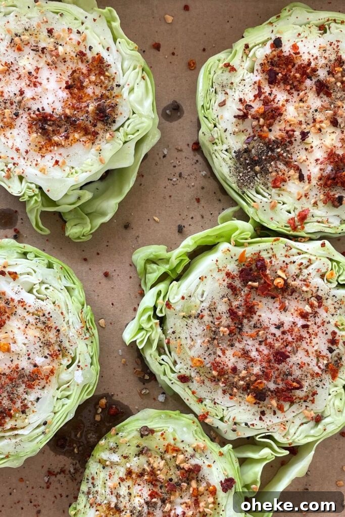 Crispy Roasted Cabbage Steaks with Garlic and Parmesan 5 seasoned cabbage steaks on a baking sheet