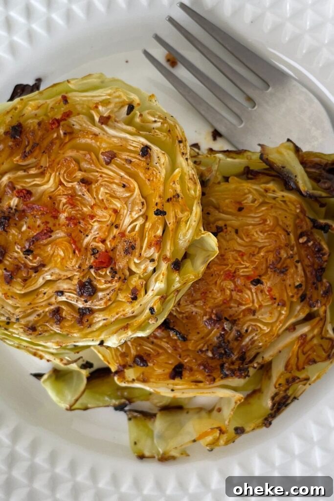Crispy Roasted Cabbage Steaks with Garlic and Parmesan 6 baked cabbage on a white plate with fork by it