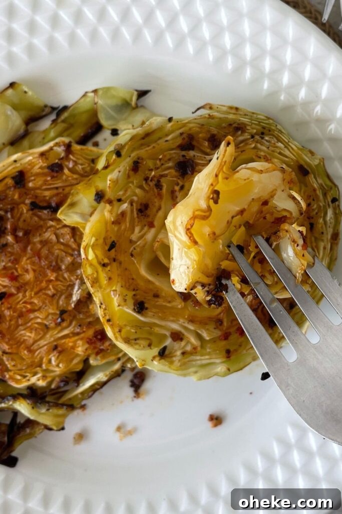 Crispy Roasted Cabbage Steaks with Garlic and Parmesan 7 sliced cabbage on plate with fork of cabbage above