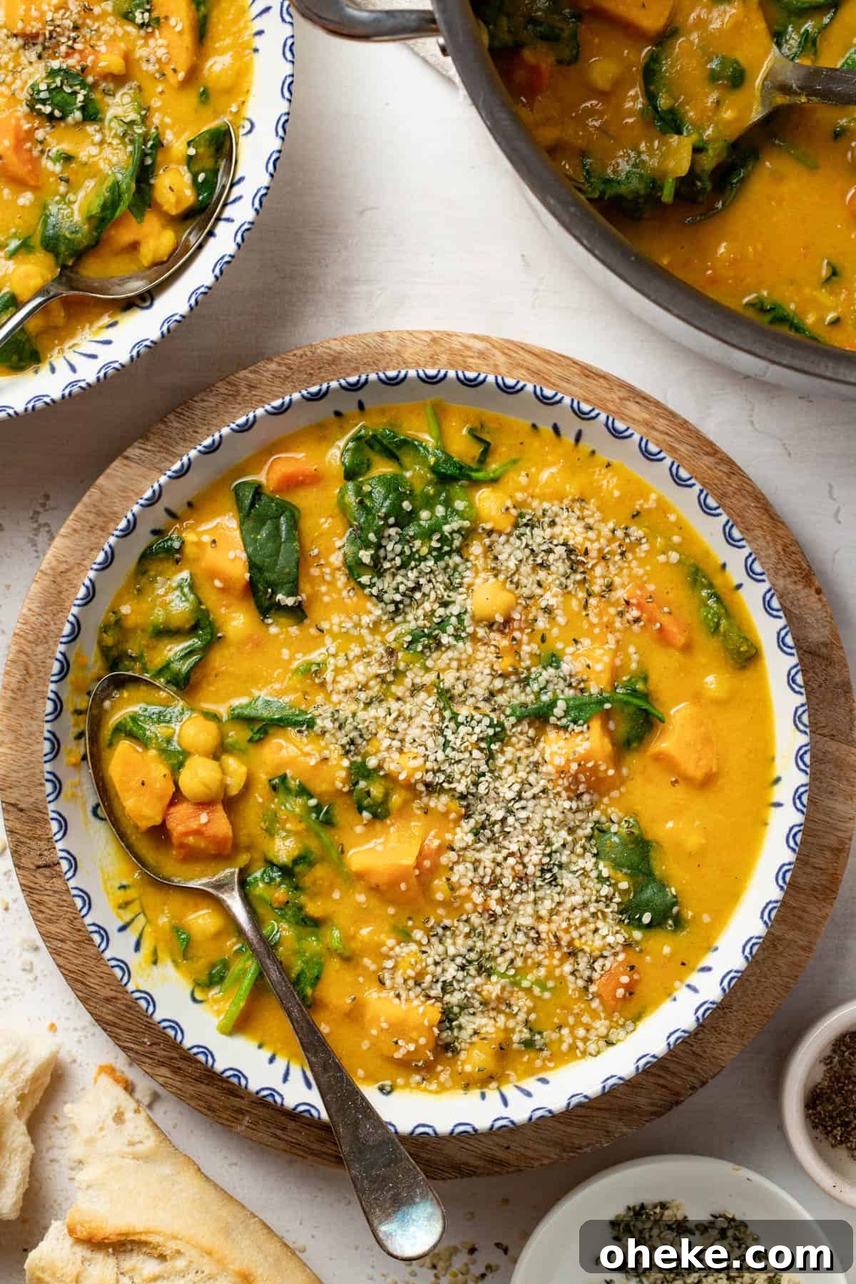Turmeric Ginger Chickpea Stew to Reduce Inflammation 2 Chickpea stew with turmeric and ginger in a blue and white bowl on top of a cutting board.