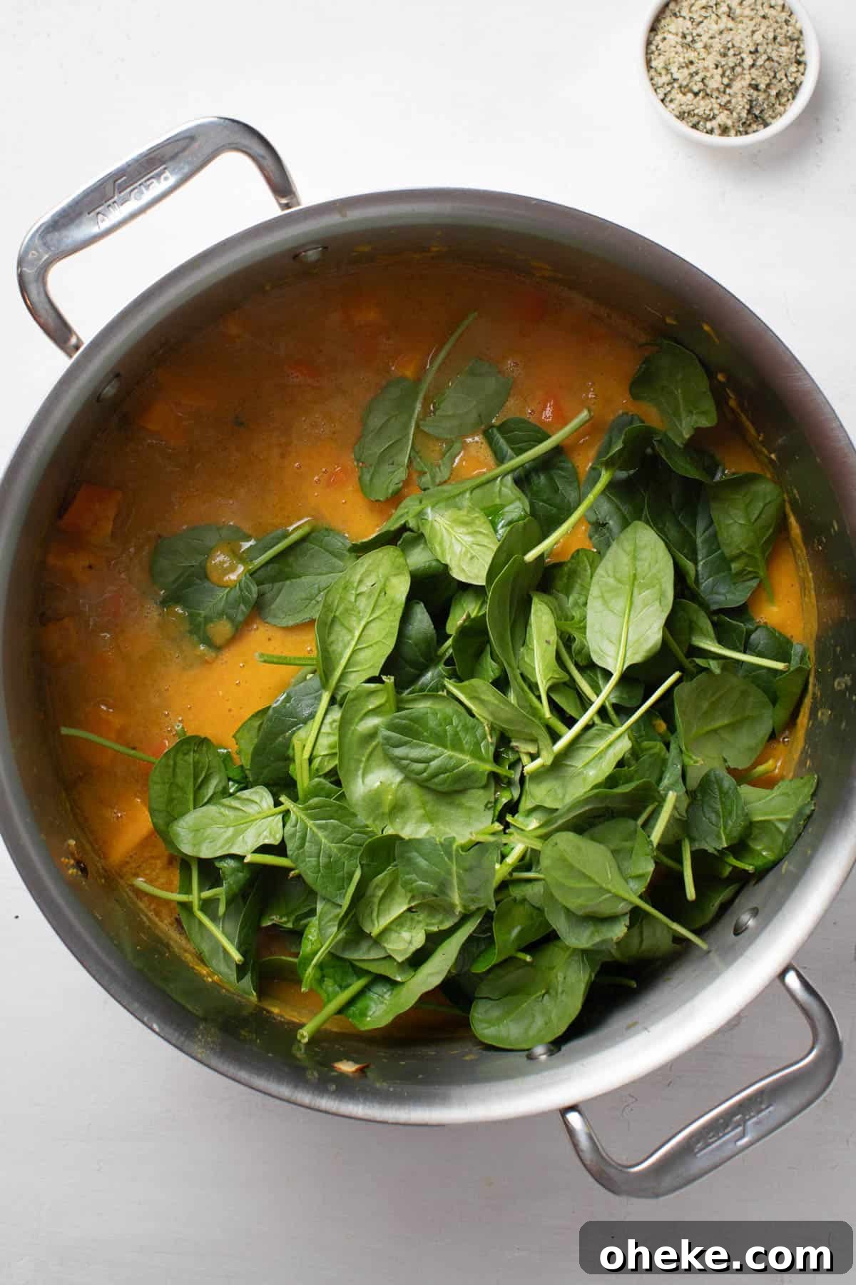 Turmeric Ginger Chickpea Stew to Reduce Inflammation 8 Adding fresh spinach leaves to the soup.