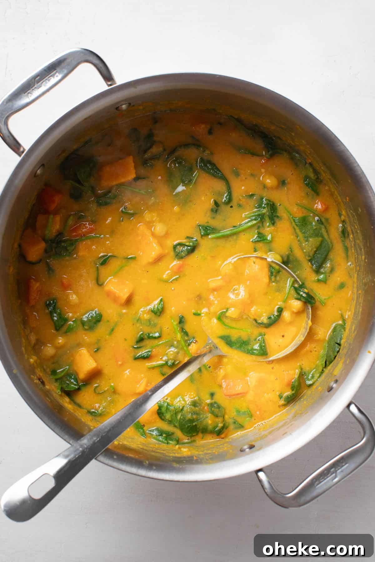 Turmeric Ginger Chickpea Stew to Reduce Inflammation 9 Stirring the cooked spinach into the chickpea stew.