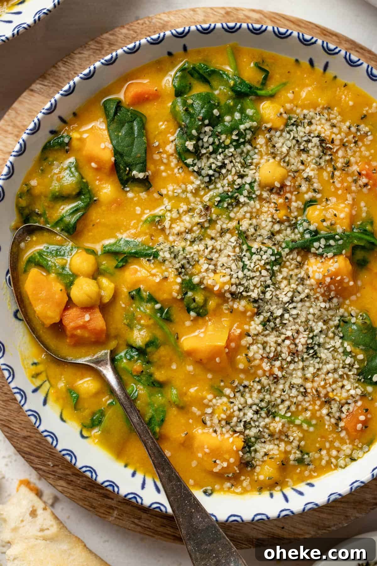 Turmeric Ginger Chickpea Stew to Reduce Inflammation 10 Sweet potato and chickpea stew with coconut milk and spinach in a bowl with a spoon.
