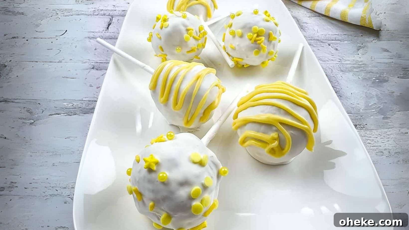 Lemon cake pops on a white plate.
