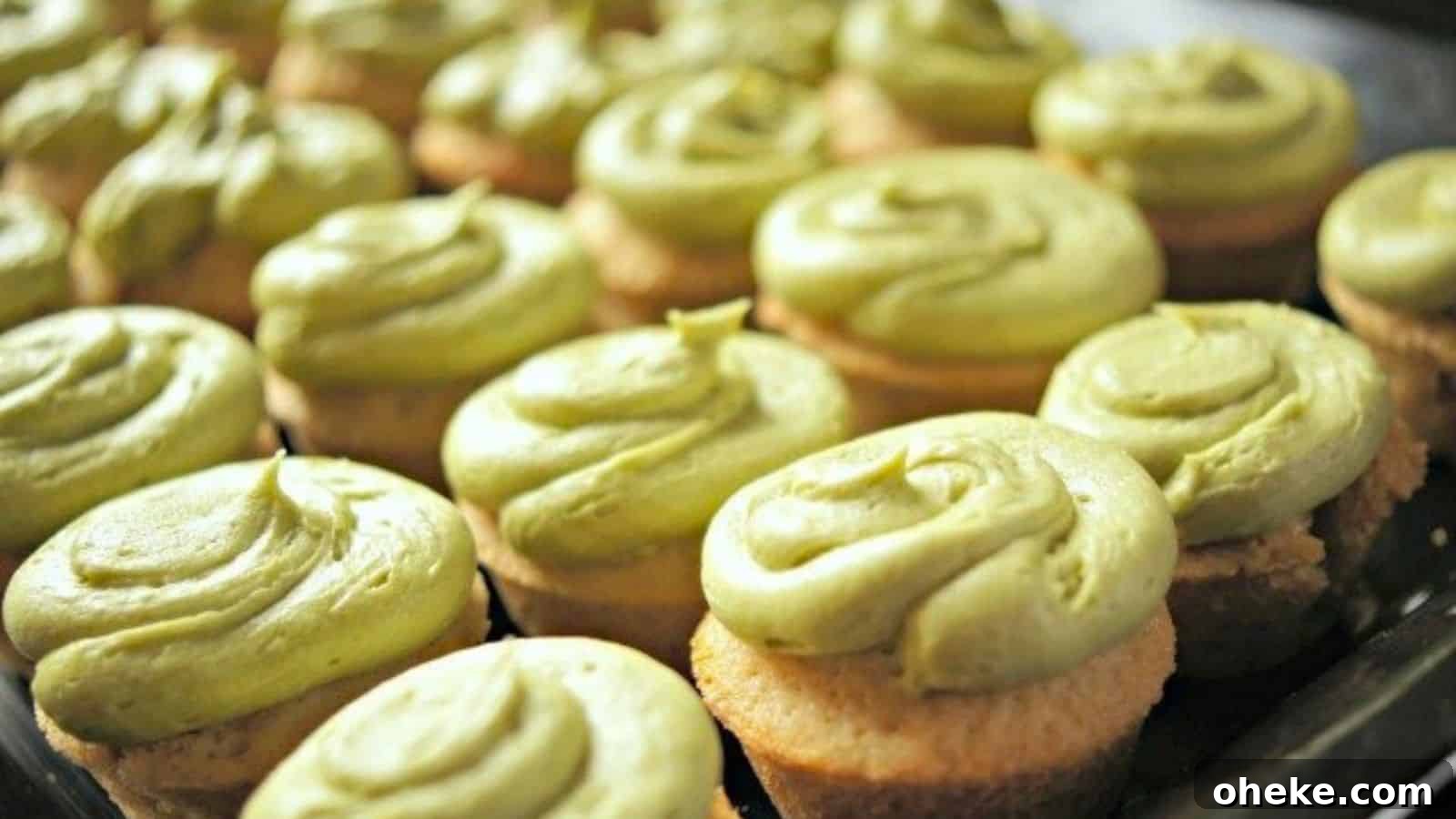 Image shows A tray of green tea cupcakes with matcha frosting on them.