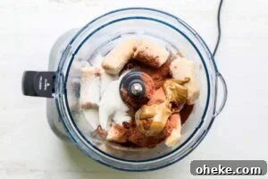 Thick Dreamy Chocolate Smoothie Bowl Recipe for Breakfast 10 Frozen bananas, cacao powder, and sunbutter shown in a food processor.