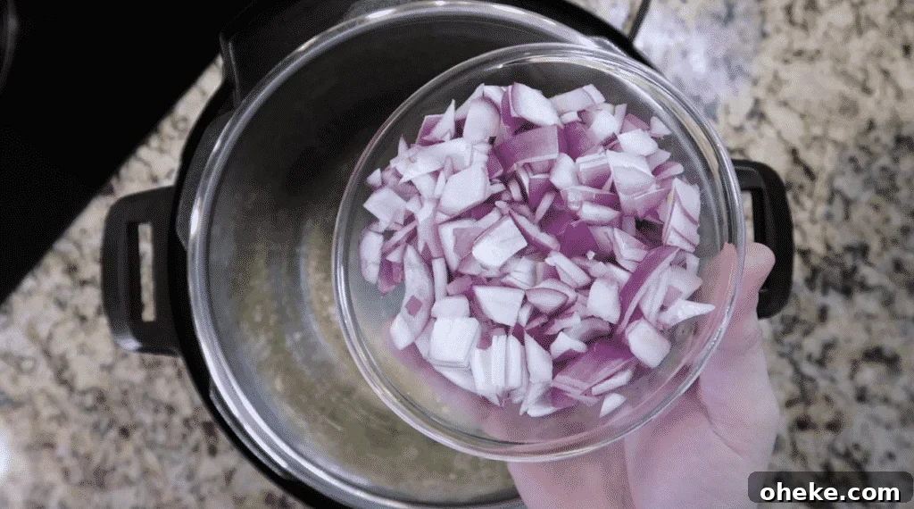 Adding diced red onion to pot.