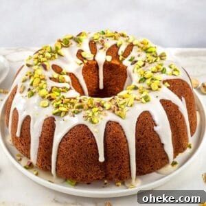 Pistachio bunt cake topped with glaze and chopped pistachios.