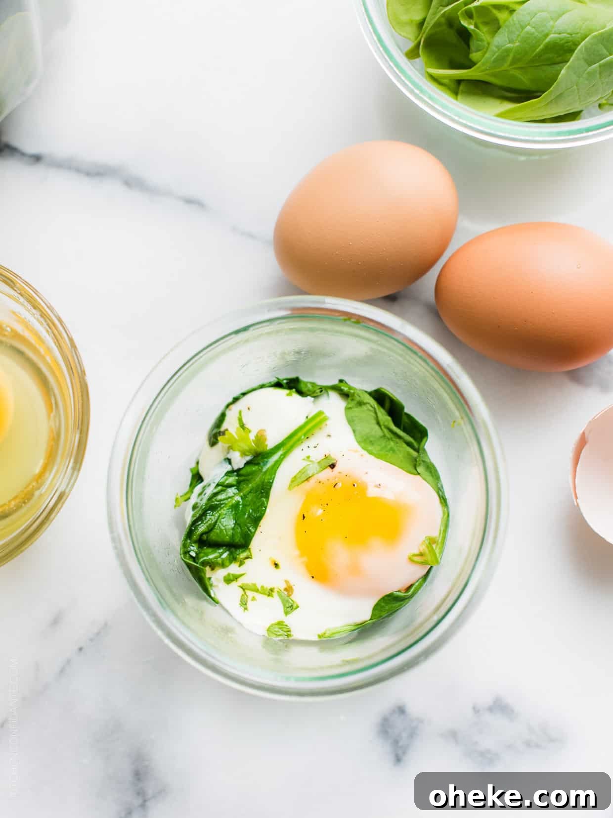 Waffle Breakfast Sandwich Ideas for Quick Morning Meals 3 Egg and spinach in a mason jar surrounded by more fresh eggs on a marble surface.