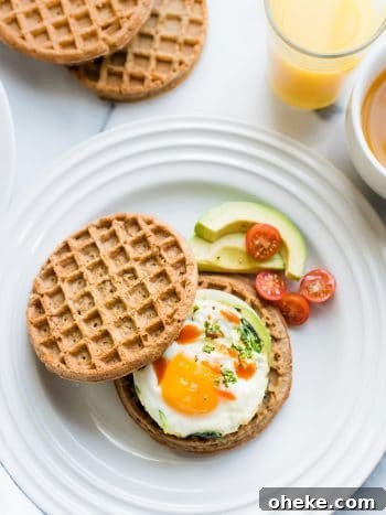 Waffle Breakfast Sandwich Ideas for Quick Morning Meals 6 Two wholegrain waffles, one topped with an over easy egg, spinach, avocado, and hot sauce to form a Waffle Breakfast Sandwich.