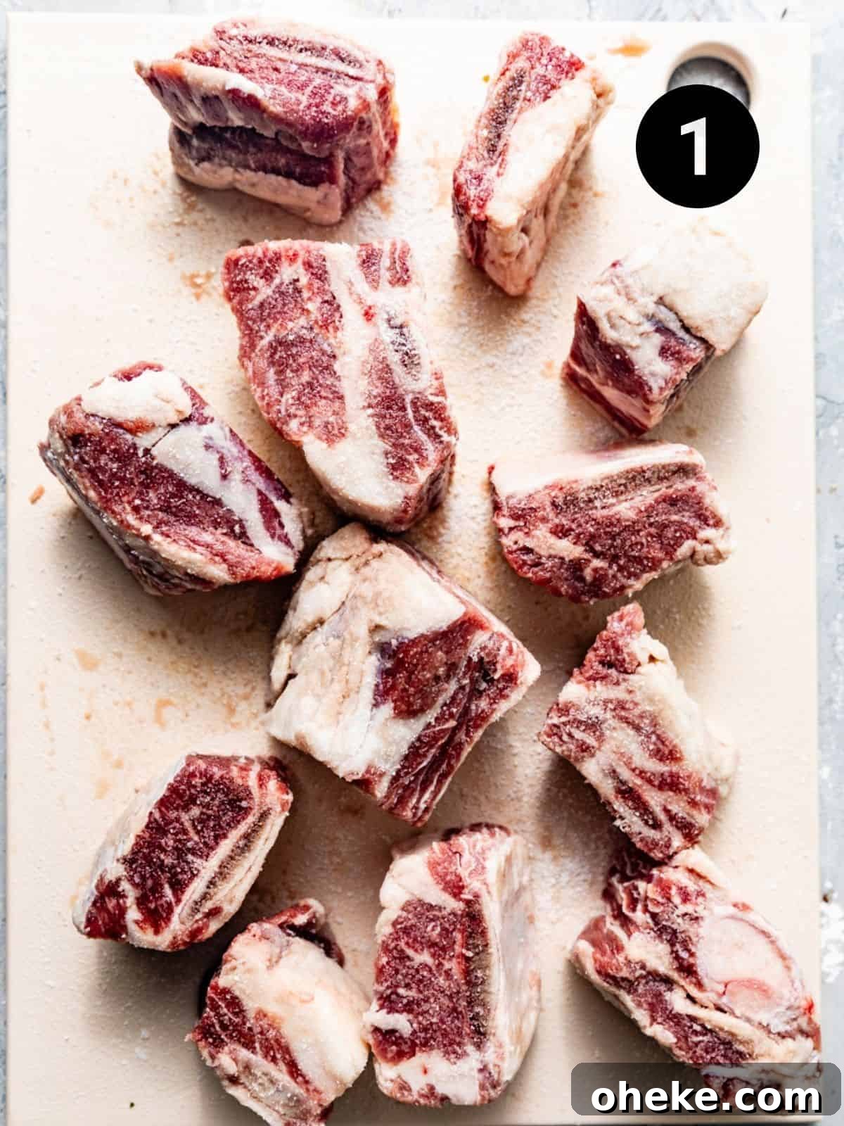 Short Rib Bolognese Recipe: Slow-Simmered, Rich Italian Ragu 4 short ribs on a cutting board seasoned with salt and black pepper.