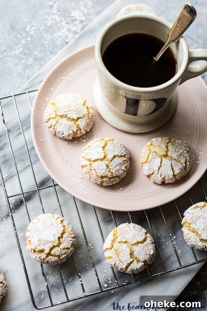 Classic Italian Amaretti Cookies Recipe — Crispy, Almond-Flavored Treats 5 Overhead photo of amaretti cookies on a plate with a cup of coffee