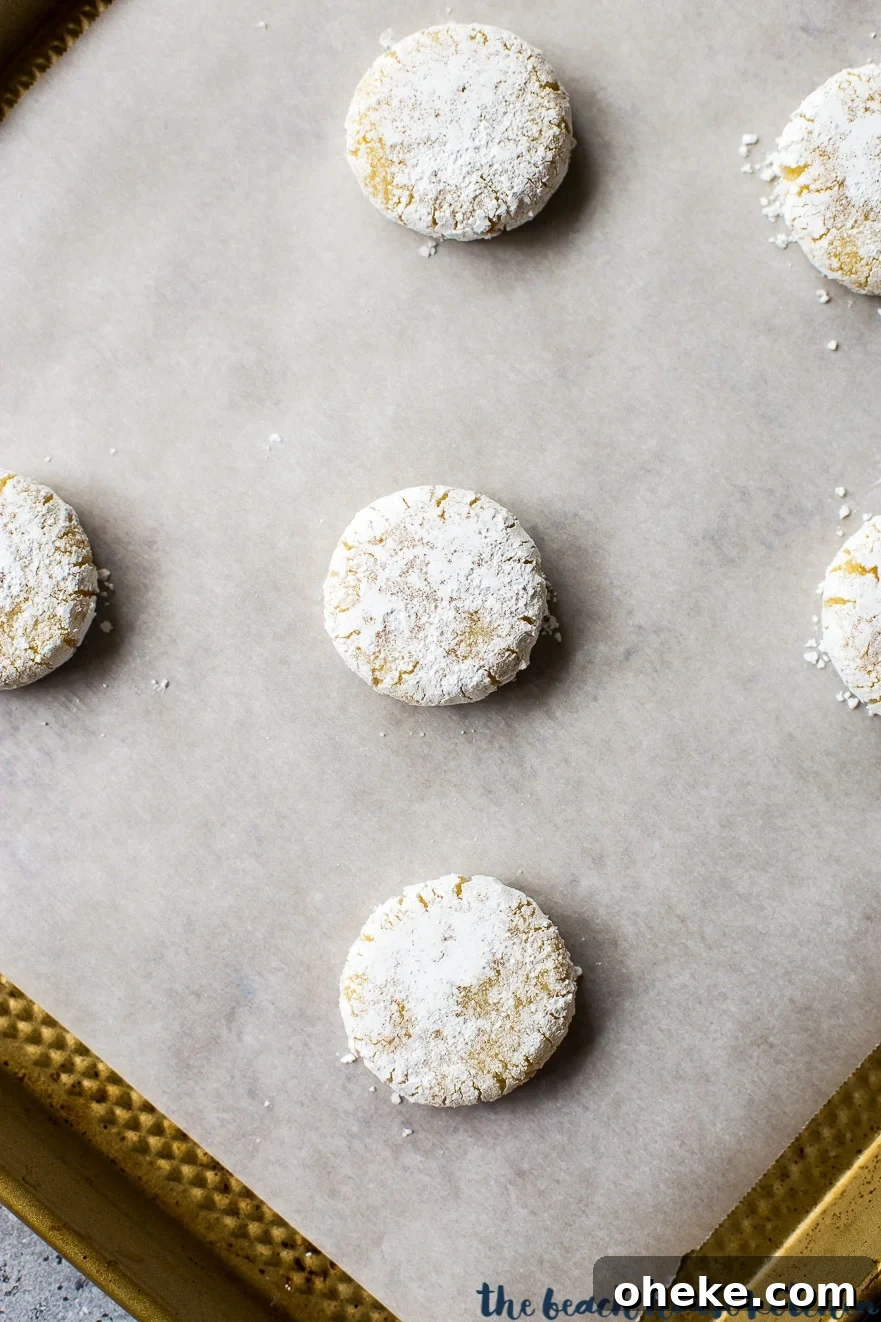 Classic Italian Amaretti Cookies Recipe — Crispy, Almond-Flavored Treats 7 Amaretti cookies on a baking sheet lined with parchment paper