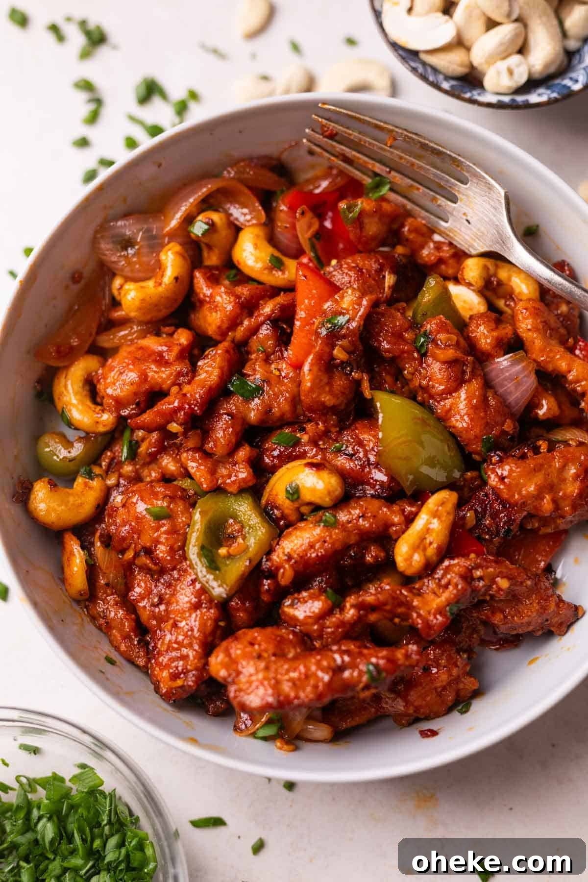 dragon chicken served in a white bowl with a fork
