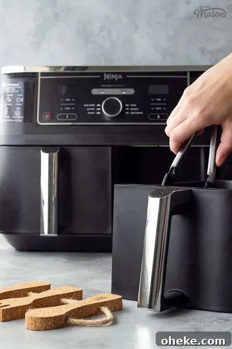 Air Fryer Buying Guide: What to Know Before You Buy 9 Someone getting food out of an air fryer drawer