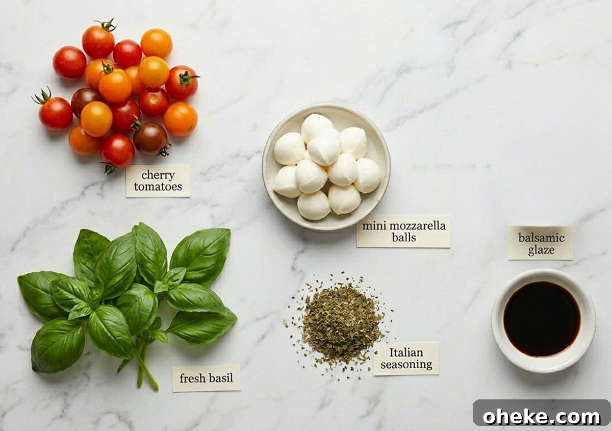 Caprese Skewers on One Pan: Quick Tomato, Basil & Mozzarella Recipe 3 Ingredients for recipe on white marble background- fresh basil, Italian seasoning, cherry tomatoes, mozzarella balls, balsamic glaze.