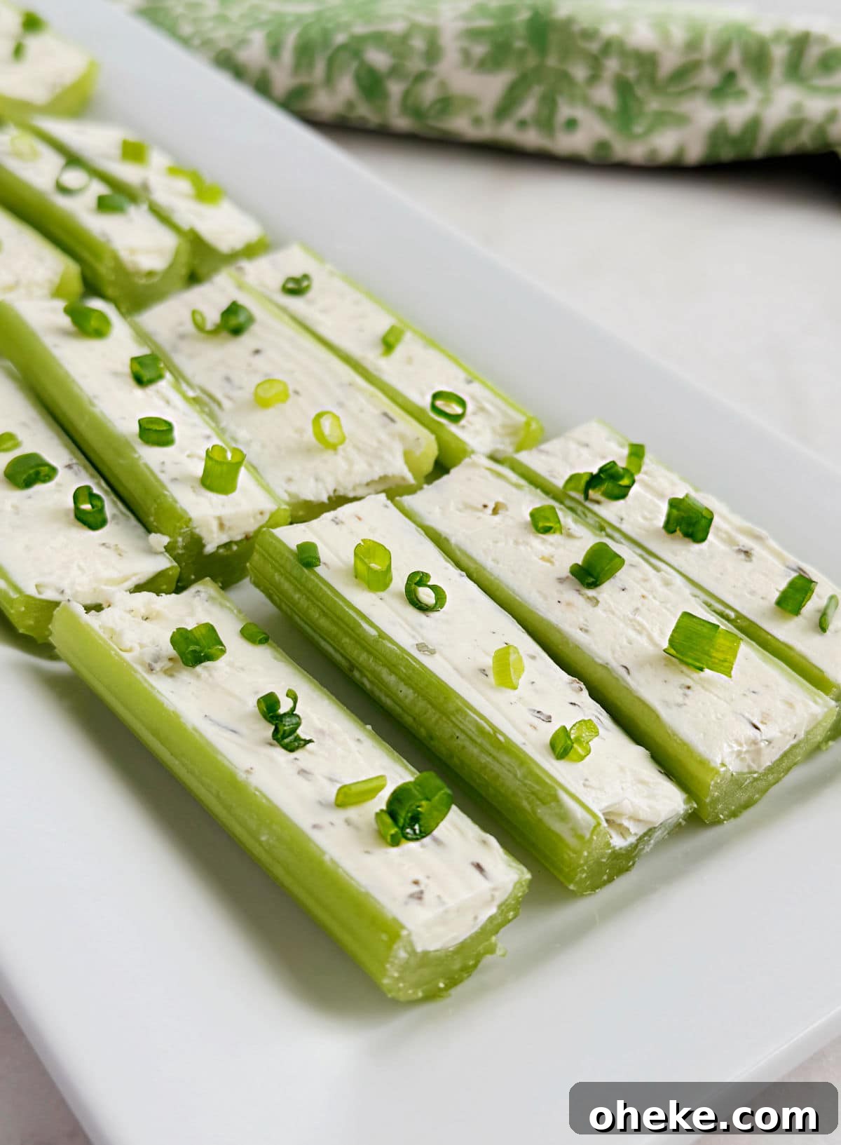 Mom’s Classic Stuffed Celery Recipe — Party Appetizer 8 celery stuffed with cream cheese and chives on serving tray.