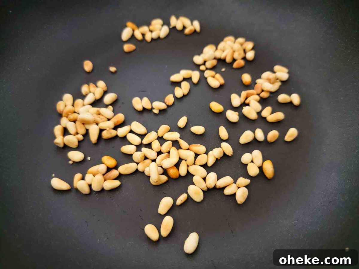 pine nuts cooking in a dry frying pan.