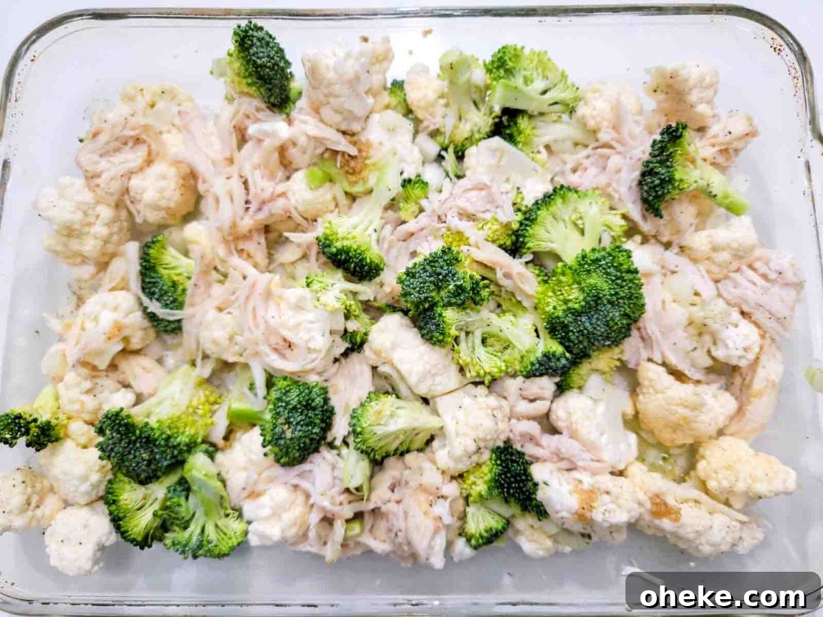 the rotisserie chicken, broccoli, cauliflower, onion, and jarred minced garlic in a 9x13-inch ovenproof casserole dish.