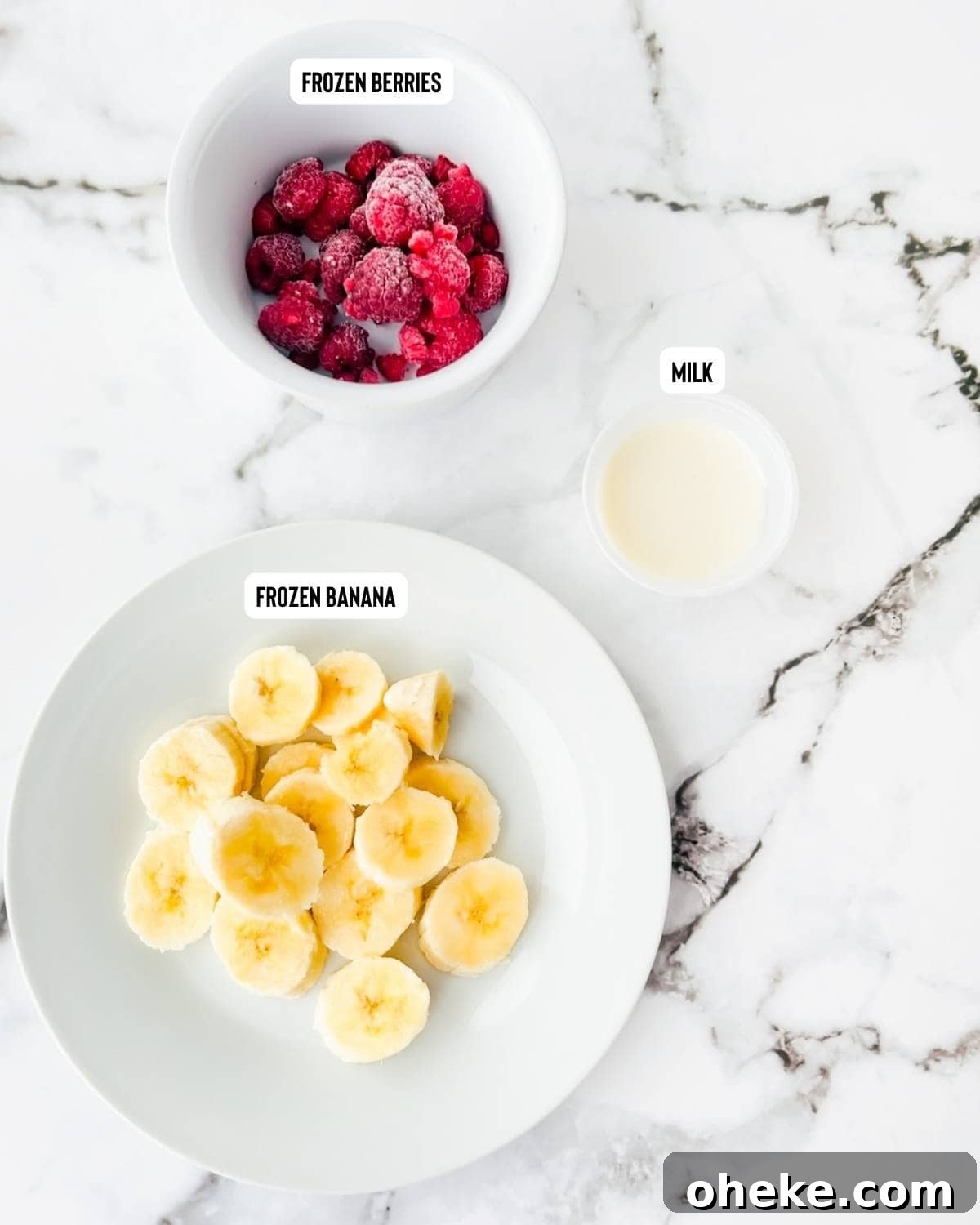 Thick & Creamy Smoothie Bowl Recipe for Spoonable Breakfast 3 Carefully measured ingredients for a nutrient-rich thick smoothie bowl, including vibrant frozen fruits and almond milk, arranged neatly on a pristine white table.
