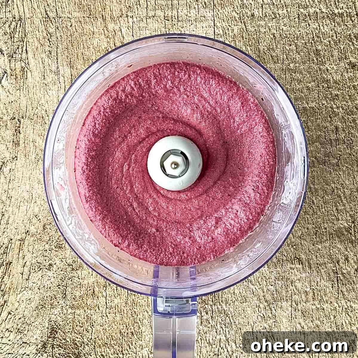 Thick & Creamy Smoothie Bowl Recipe for Spoonable Breakfast 5 A creamy, evenly blended mixture of smoothie bowl ingredients, showcasing a rich texture in the food processor's bowl, ready to be served.
