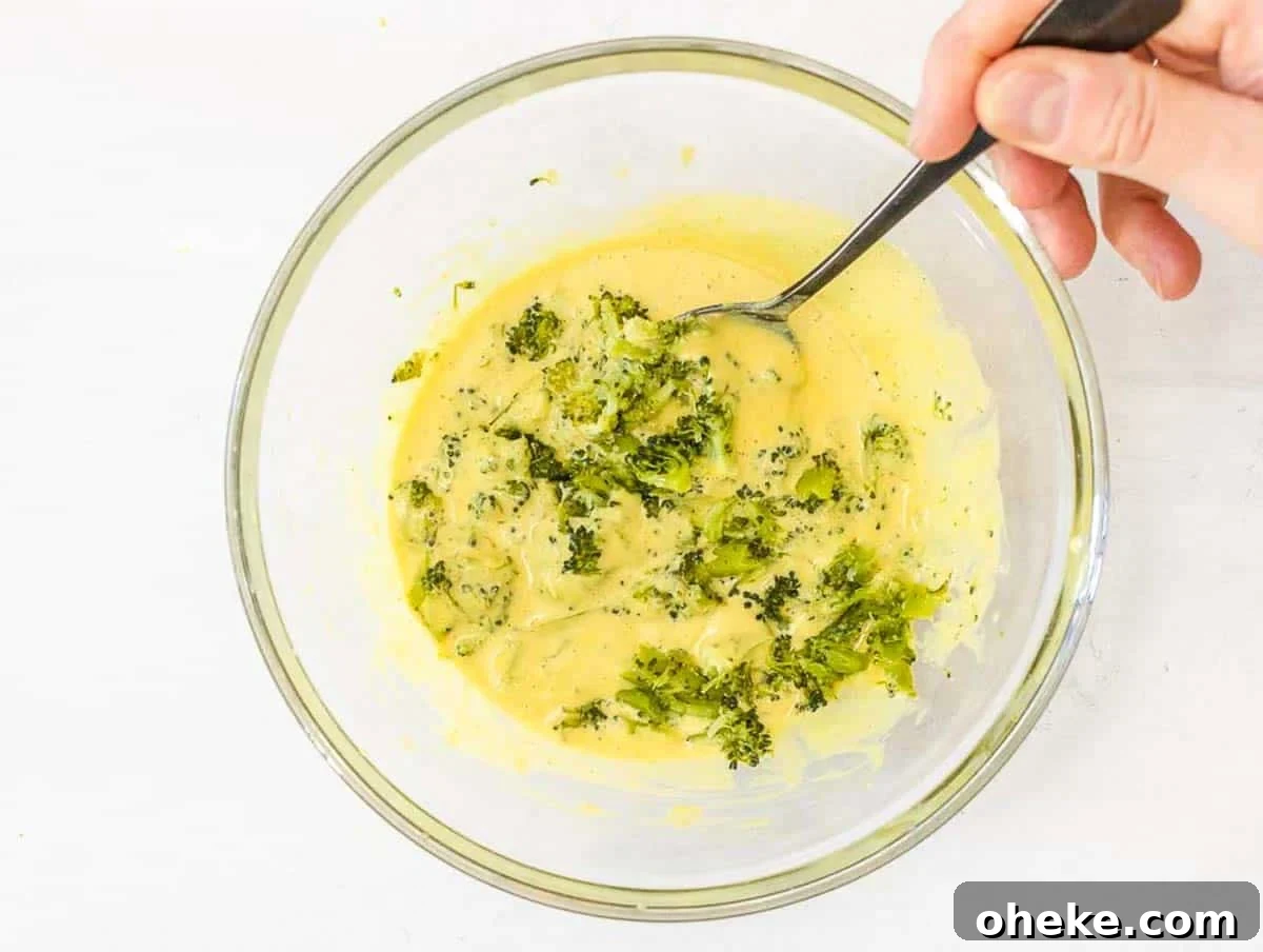 Savory Chickpea Frittata Muffins for Meal Prep 12 Chickpea Muffins with steamed broccoli and hand holding a spoon