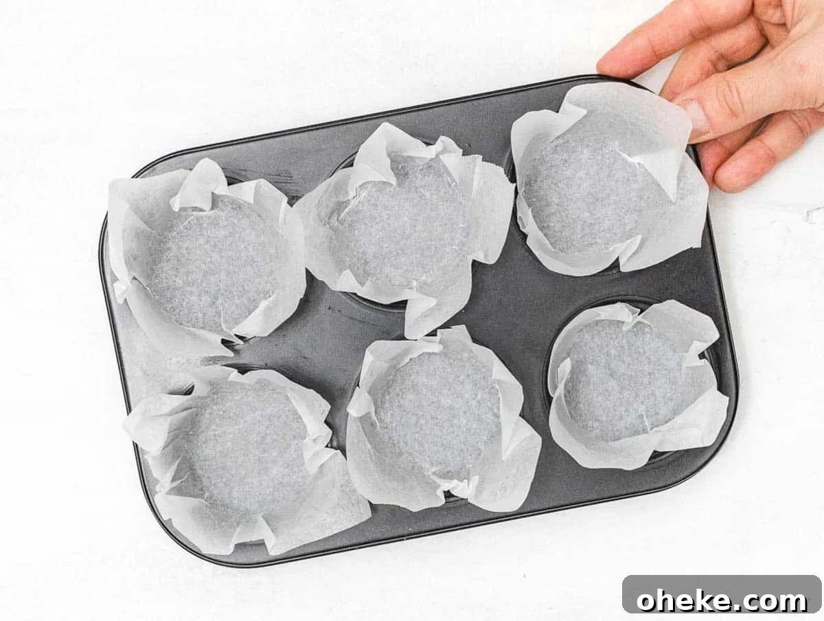 Savory Chickpea Frittata Muffins for Meal Prep 8 muffin pan with baking paper and a hand