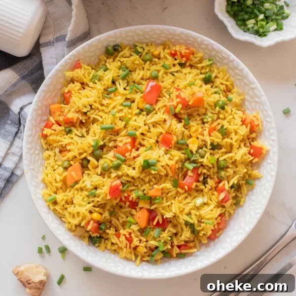 Wok-Seared Pineapple Fried Rice with Shrimp and Cashews 15 Overhead image of Nigerian fried rice on a white plate.