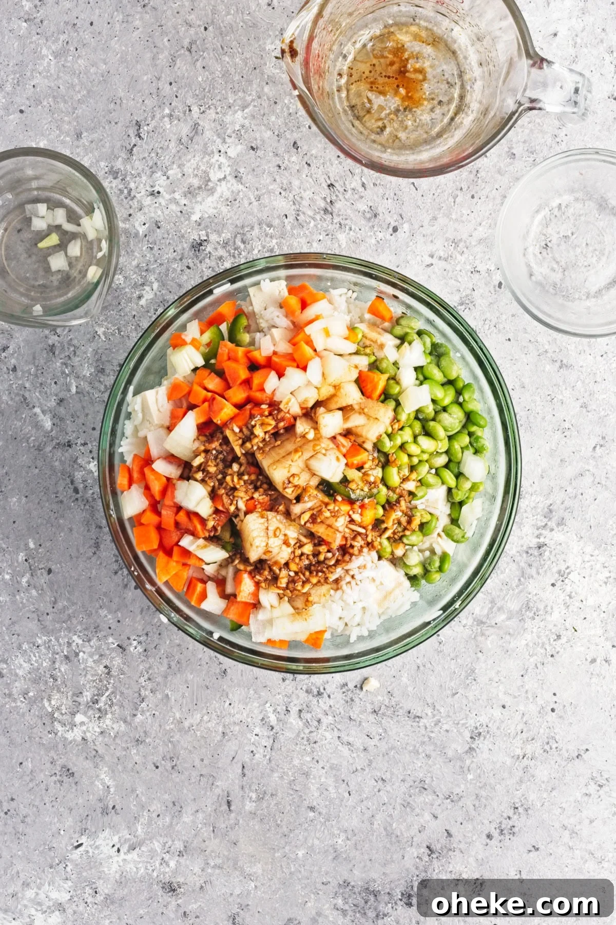 Wok-Seared Pineapple Fried Rice with Shrimp and Cashews 9 An overhead image of adding the sauce to the mixture.
