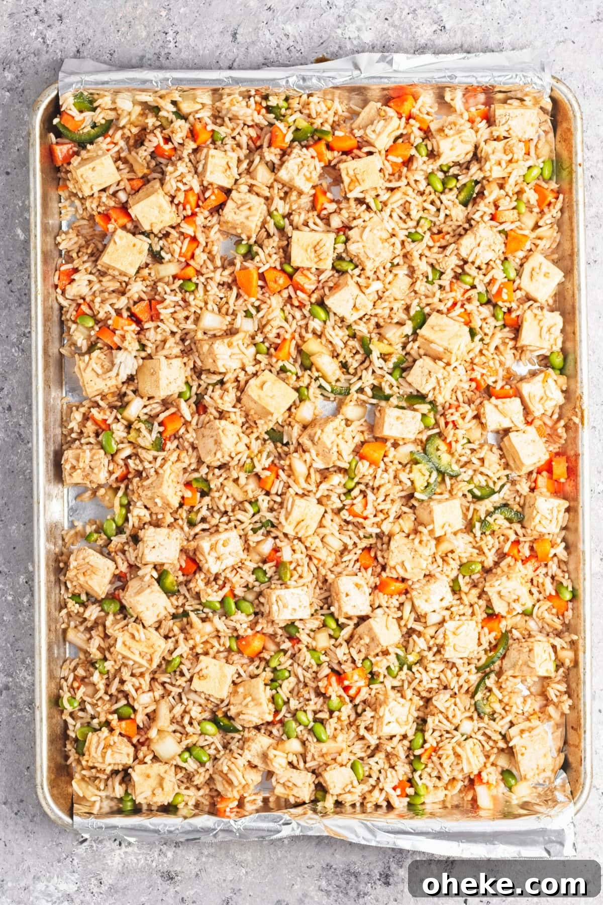 Wok-Seared Pineapple Fried Rice with Shrimp and Cashews 10 An overhead image of spreading the rice mixture on a sheet pan.
