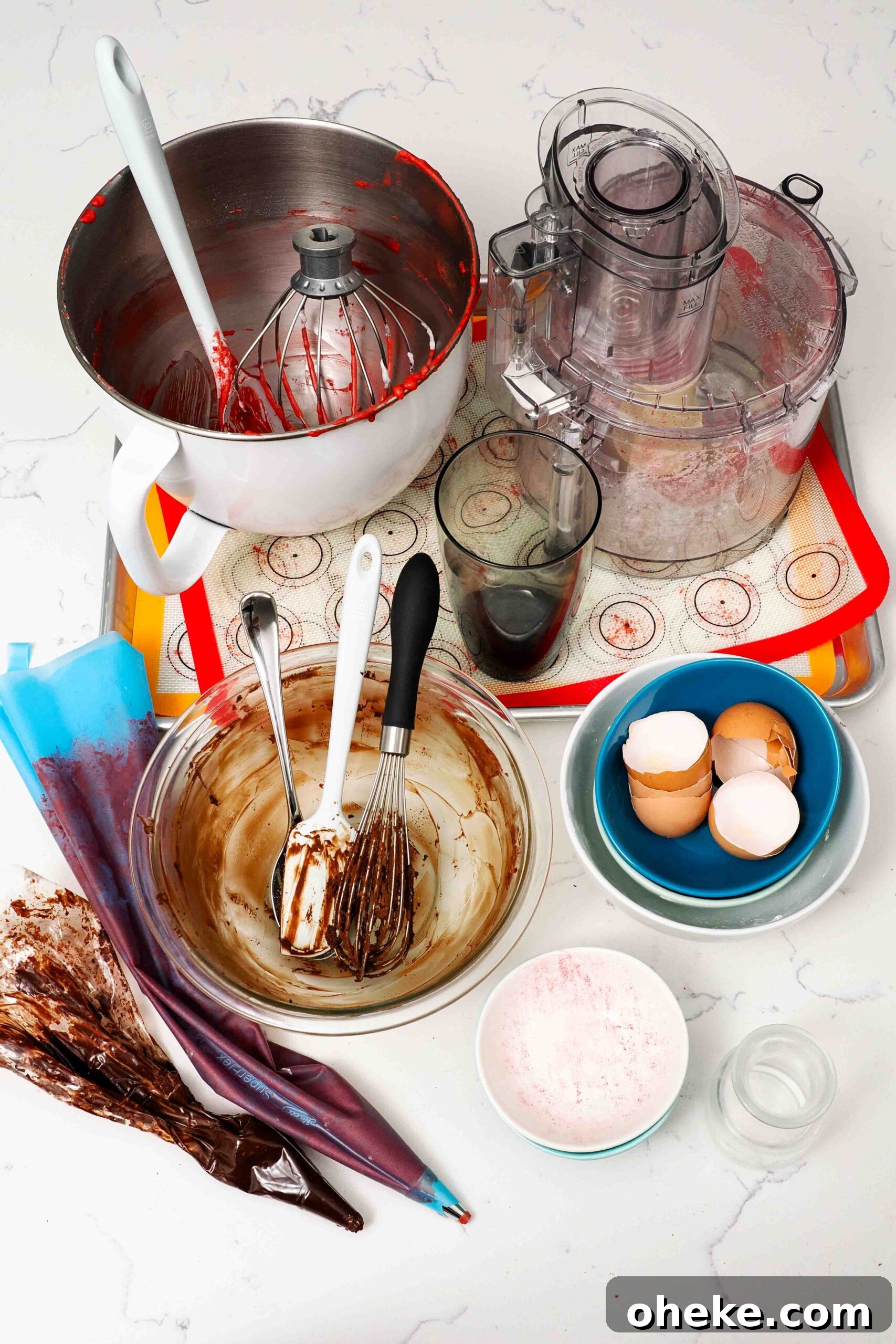 Heart-Shaped Chocolate Raspberry Macarons Recipe 19 Dishes used to make chocolate raspberry macarons on a quartz countertop.