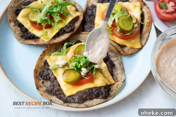 Spooning burger sauce over smash burger taco