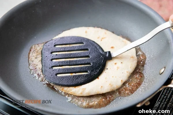 Pressing tortilla with a spatula