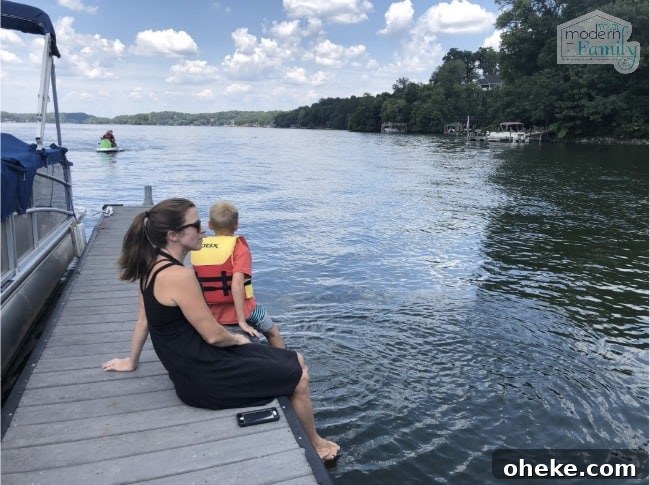 A person sitting on a dock by a body of water.