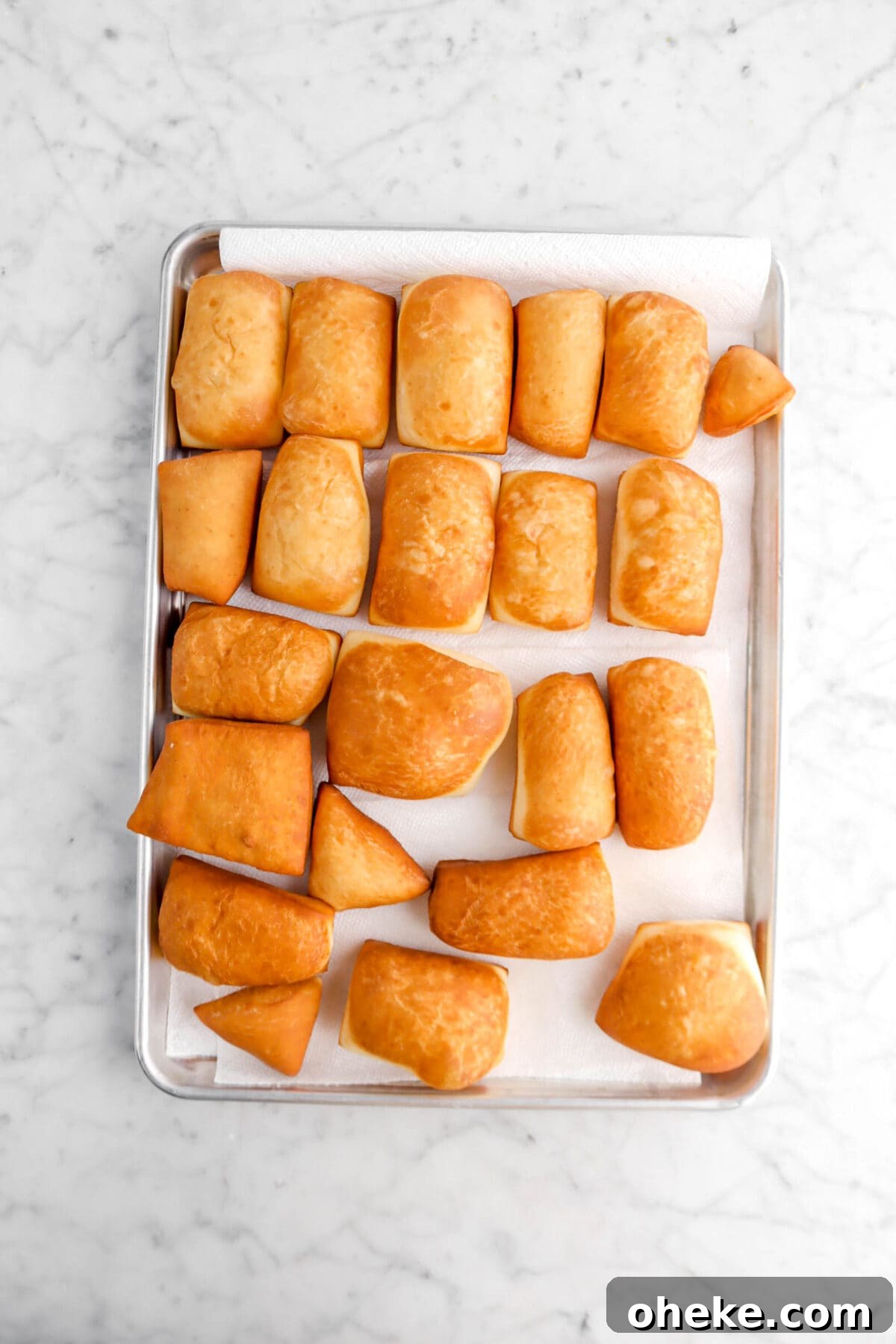fried beignets on lined sheet pan