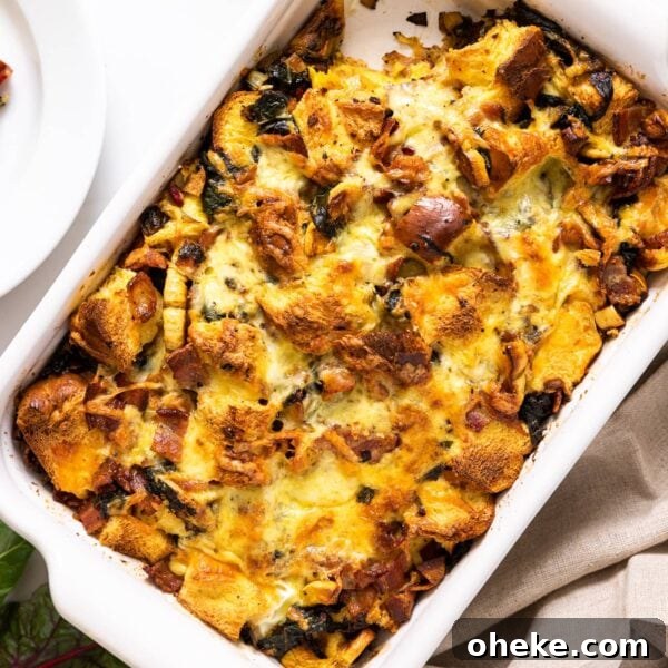 Top down view of white casserole dish filled with brown colored egg strata sitting on white countertop