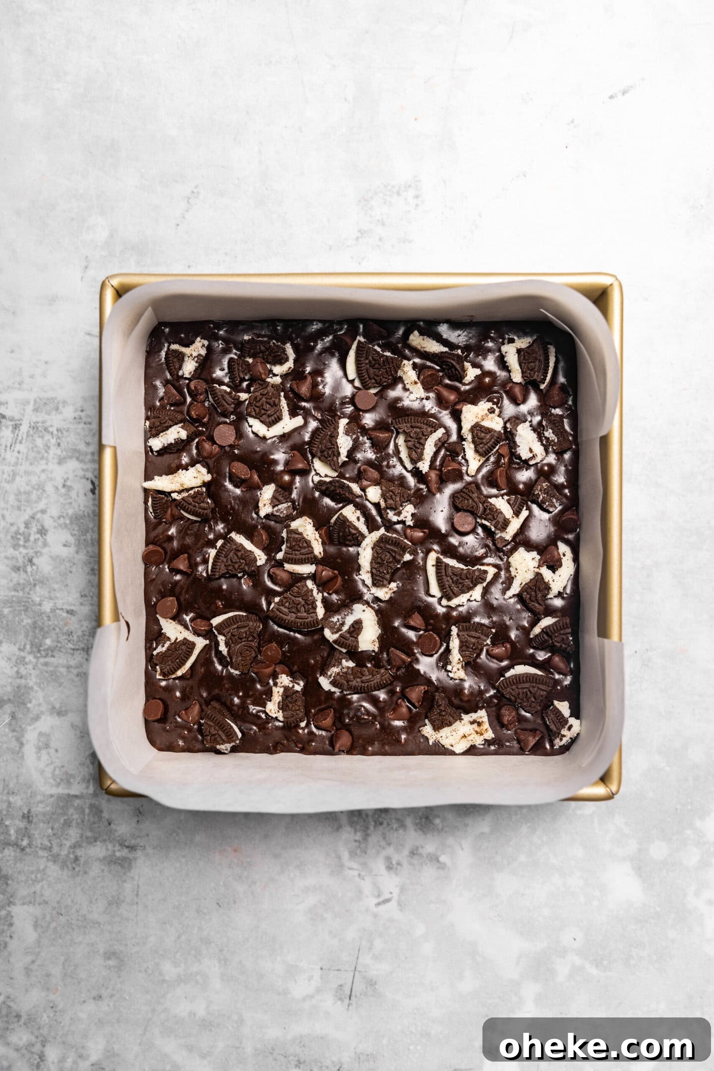 Brownie batter being spread into baking pan.