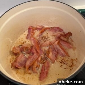 Southern-Style Green Beans and Potatoes Recipe for Comforting Sides 5 Bacon cooking in a dutch oven.